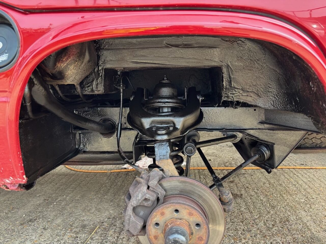 Finished arch — painted, sealed, suspension and brake assembly visible